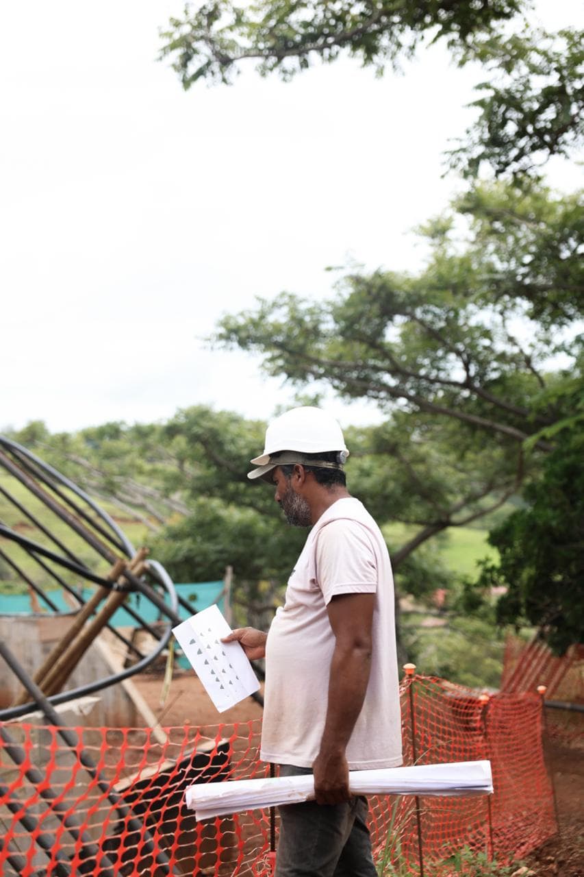 A worker holding construction plans at an active building site