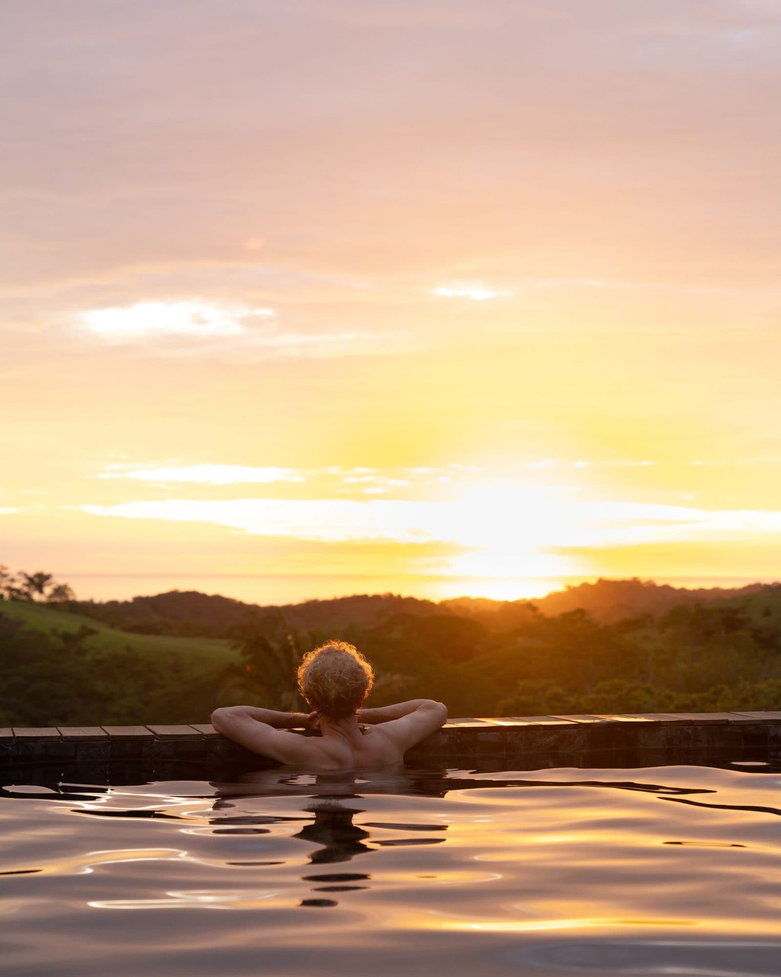 A resident watching the sunset from the pool