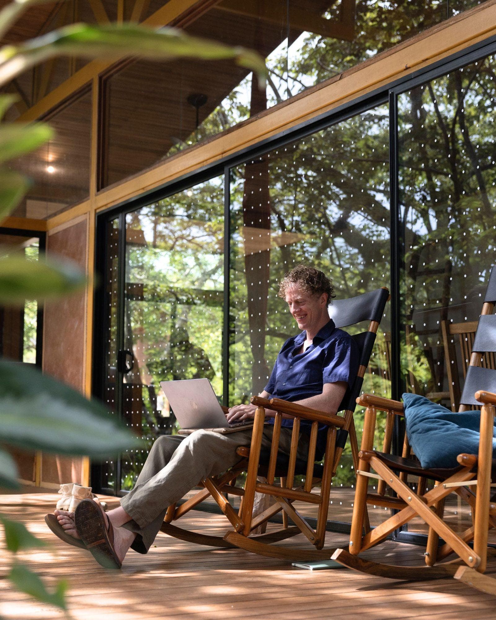 A resident working from a laptop on a casita porch