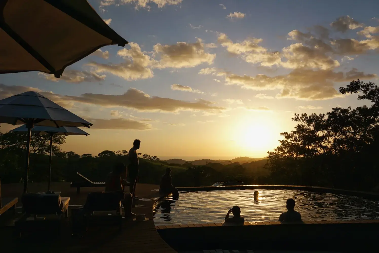 Guests at the pool at sunset